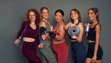 Photo for Five young women in sports clothes and gym accessories in studio shot - Royalty Free Image