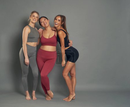 Téléchargez les photos : Full length portrait of three woman in sports clothes in studio shot - en image libre de droit