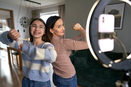 Photo for Teenager girl recording how dancing with mom at home - Royalty Free Image