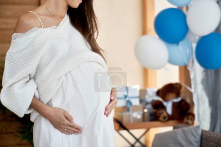 Téléchargez les photos : Partie de femme enceinte avec des décorations bleues à l'extérieur - en image libre de droit