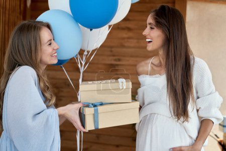 Téléchargez les photos : Femme caucasienne donnant des cadeaux à un ami enceinte - en image libre de droit