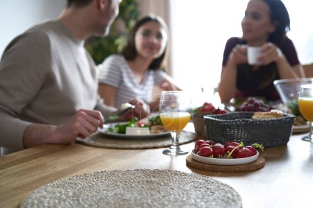 Téléchargez les photos : Close up of lunch on the table and caucasian family in background - en image libre de droit