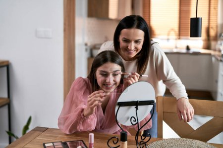 Photo for Caucasian mother helping daughter with makeup before prom - Royalty Free Image