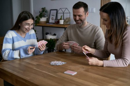 Téléchargez les photos : Caucasien heureux famille jouer dans la carte à la maison - en image libre de droit