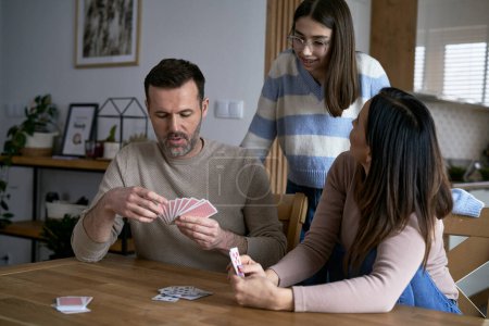 Photo for Caucasian family playing in card together and relaxing at home - Royalty Free Image
