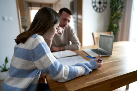 Photo for Caucasian father with teenager daughter make homework at home - Royalty Free Image