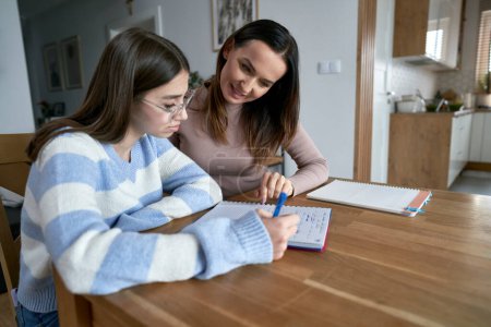 Photo for Caucasian mother with teenager daughter make homework at home - Royalty Free Image