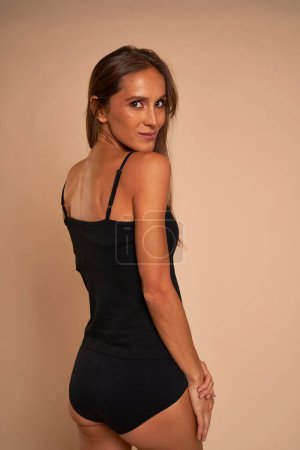 Photo for Skinny woman in black underwear turning towards the camera - Royalty Free Image