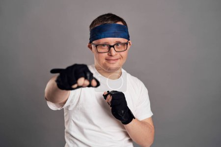 Photo for Man with down syndrome boxing on gray background - Royalty Free Image