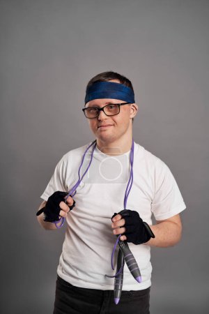 Foto de Man with down syndrome with sporty clothes on gray background - Imagen libre de derechos