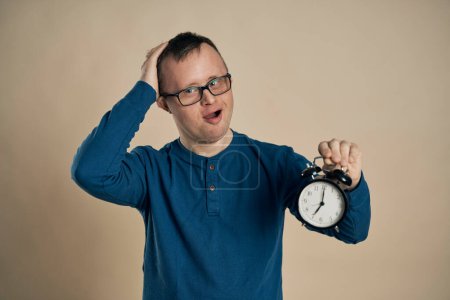 Photo for Caucasian man with down syndrome holding alarm - Royalty Free Image