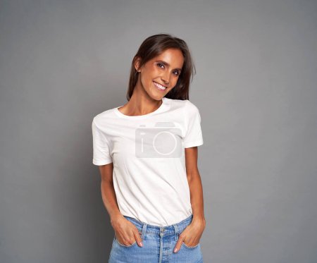 Téléchargez les photos : Portrait de jeune femme caucasienne portant un jean bleu et un t-shirt blanc sur fond gris - en image libre de droit