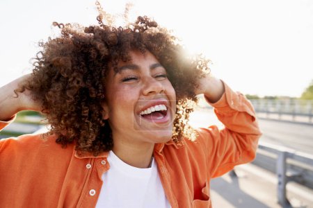 Téléchargez les photos : Femme noire très heureuse dans la rue avec les yeux fermés - en image libre de droit