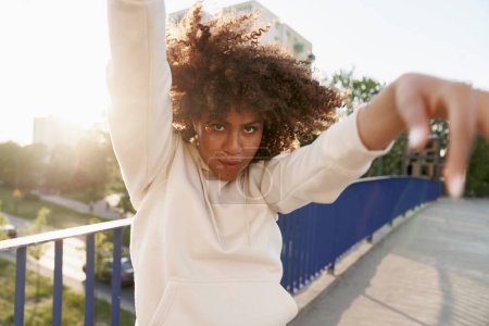 Photo for Black woman  dancing on the bridge and looking at camera - Royalty Free Image