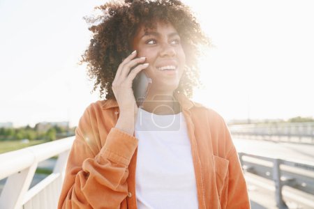 Photo for Black woman calling on the phone on the bridge - Royalty Free Image