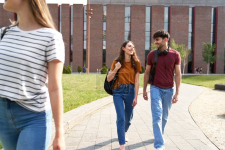 Téléchargez les photos : Deux étudiants caucasiens marchant à travers le campus universitaire - en image libre de droit