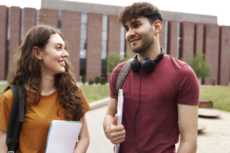 Téléchargez les photos : Deux étudiants universitaires caucasiens debout à l'extérieur du campus universitaire et parlant - en image libre de droit