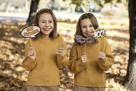 Téléchargez les photos : Deux filles caucasiennes avec des accessoires d'Halloween au parc - en image libre de droit