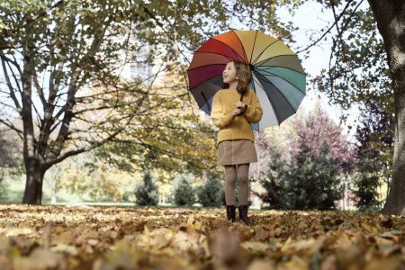 Téléchargez les photos : Fille caucasienne dans le parc tenant un parapluie coloré - en image libre de droit
