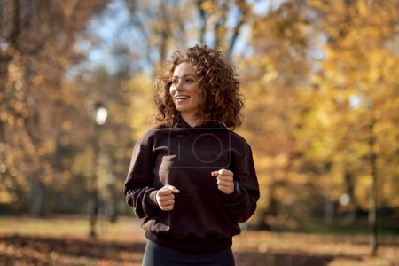 Téléchargez les photos : Femme caucasienne jogging dans le parc en automne - en image libre de droit