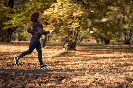 Téléchargez les photos : Gros plan de femme caucasienne jogging dans le parc à l'automne - en image libre de droit
