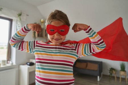 Foto de Caucásico chica vistiendo traje de superhéroe y mostrando fuerza - Imagen libre de derechos