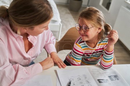 Photo for Mother helping daughter in doing homework - Royalty Free Image