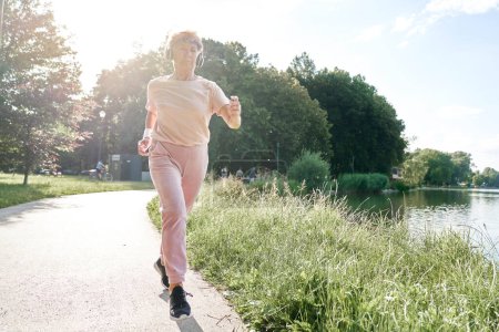 Téléchargez les photos : Femme âgée jogging dans le parc en été - en image libre de droit