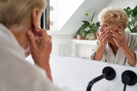 Foto de Mujer joven caucásica en el baño que tiene problemas con la piel de la cara - Imagen libre de derechos