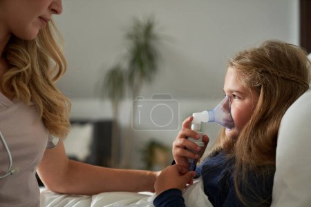 Foto de Pediatra dando nebulizador a un niño enfermo en hom - Imagen libre de derechos