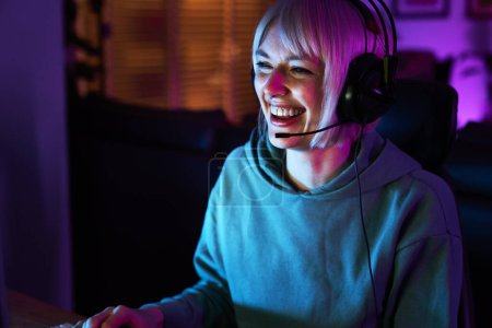 Photo for Caucasian young woman playing game at night among neon lightning - Royalty Free Image