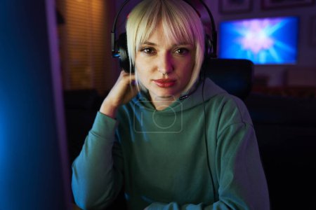 Téléchargez les photos : Portrait de jeune joueur de jeu vidéo parmi les couleurs fluo - en image libre de droit