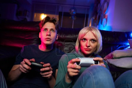 Téléchargez les photos : Couple caucasien jouer jeu vidéo avec des tampons de jeu - en image libre de droit