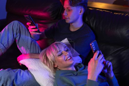 Téléchargez les photos : Caucasien couple femme navigation téléphone mobile tandis que la nuit - en image libre de droit