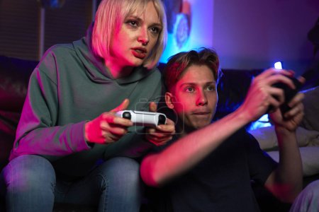 Foto de Primer plano de joven pareja caucásica jugando videojuego con almohadillas de juego - Imagen libre de derechos