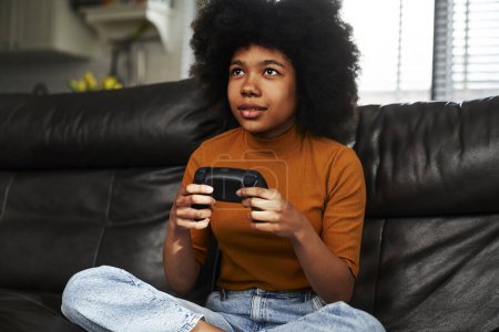 Foto de Adolescente chica jugando videojuego en la sala de estar - Imagen libre de derechos