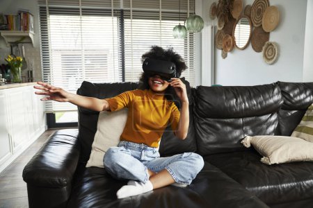 Foto de Amplia toma de chica adolescente con simulador de realidad virtual para jugar videojuego en la sala de estar - Imagen libre de derechos