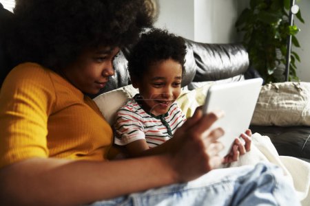 Photo for Two children browsing digital tablet in the living room - Royalty Free Image