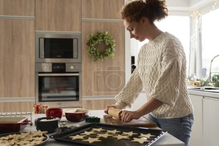 Photo for Red head woman preparing dough for the Christmas cookies - Royalty Free Image