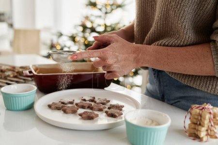 Téléchargez les photos : Femme méconnaissable décorant les biscuits de Noël avec un sucre glace - en image libre de droit