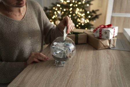 Photo for Caucasian woman saving money for Christmas presents - Royalty Free Image