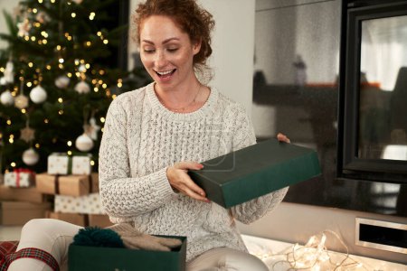 Téléchargez les photos : Femme gaie déballer des cadeaux pour Noël - en image libre de droit