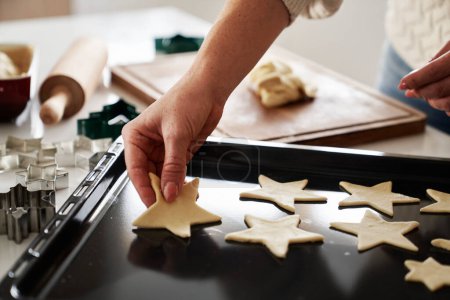 Photo for Unrecognizable woman cutting out gingerbread cookies from the dough - Royalty Free Image