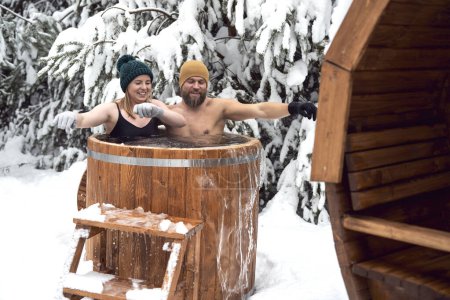 Téléchargez les photos : Couple caucasien profiter du bain d'hiver dans le tube en plein air - en image libre de droit