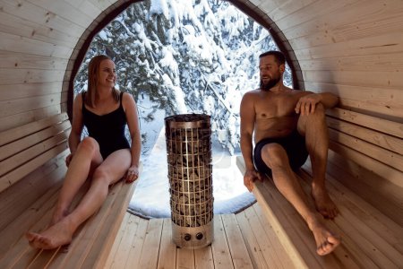 Téléchargez les photos : Caucasian adult couple enjoying in the sauna in winter - en image libre de droit