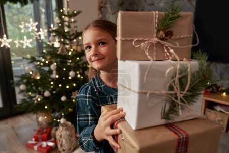 Foto de Elemental chica edad llevando un montón de regalos de Navidad - Imagen libre de derechos
