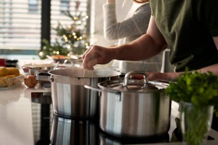 Téléchargez les photos : Couple caucasien préparant la nourriture avant Noël - en image libre de droit
