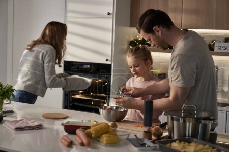 Photo for Caucasian family of three preparing food for Christmas - Royalty Free Image