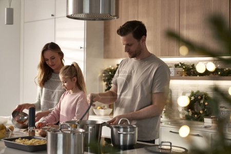 Photo for Caucasian family of three preparing food before Christmas - Royalty Free Image