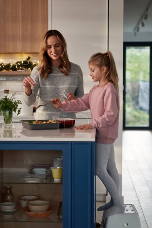 Photo for Caucasian daughter and mother preparing food before Christmas - Royalty Free Image
